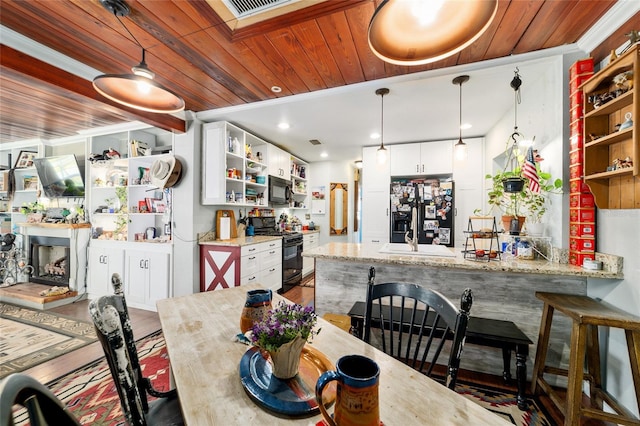 dining room with bar, wooden ceiling, wood finished floors, and visible vents