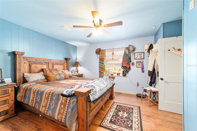 bedroom featuring light wood finished floors, visible vents, and ceiling fan