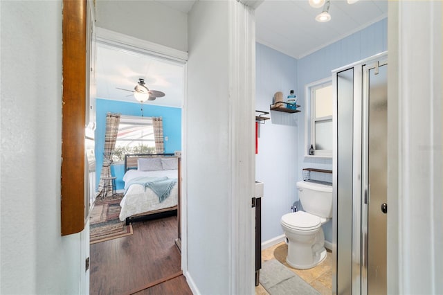 ensuite bathroom with toilet, a ceiling fan, wood finished floors, crown molding, and connected bathroom
