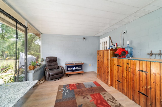 sitting room featuring wood finished floors and concrete block wall