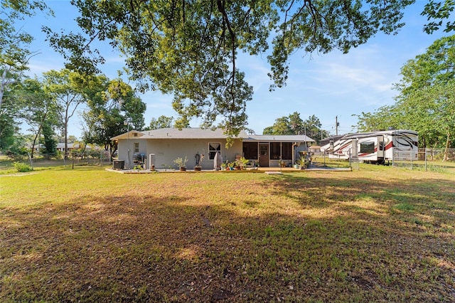 back of house with a sunroom, fence, and a yard