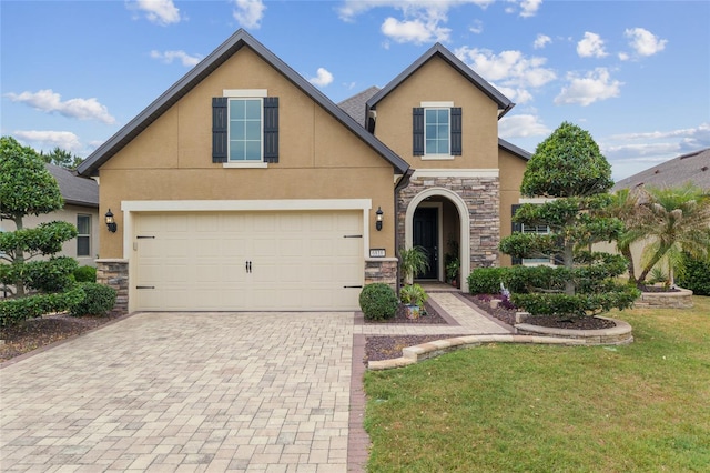 6816 SW 95th Cir, Ocala, FL 34481 - view of front of home featuring stone siding, an attached garage, a front yard, stucco siding, and decorative driveway