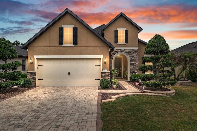 6816 SW 95th Cir, Ocala, FL 34481 - view of front of house featuring stucco siding, decorative driveway, a lawn, and stone siding