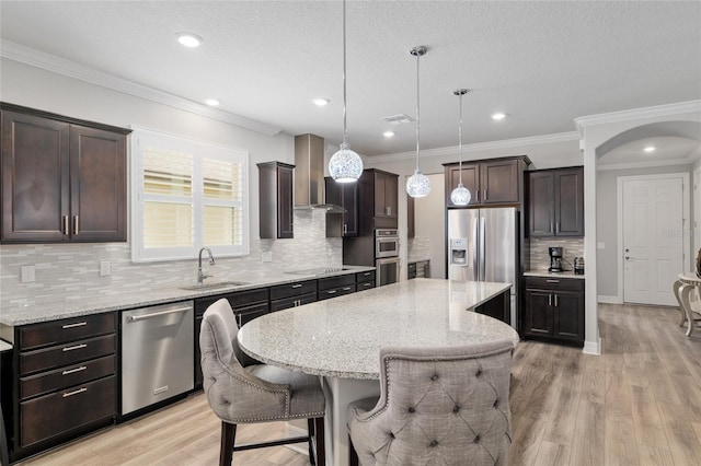 6816 SW 95th Cir, Ocala, FL 34481 - kitchen with a sink, wall chimney exhaust hood, dark brown cabinetry, appliances with stainless steel finishes, and a breakfast bar area