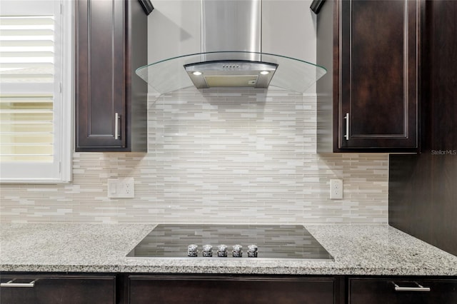 6816 SW 95th Cir, Ocala, FL 34481 - room details featuring black electric cooktop, island exhaust hood, dark brown cabinets, backsplash, and light stone countertops