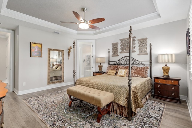 6816 SW 95th Cir, Ocala, FL 34481 - bedroom with light wood-style flooring, a tray ceiling, visible vents, a ceiling fan, and ornamental molding