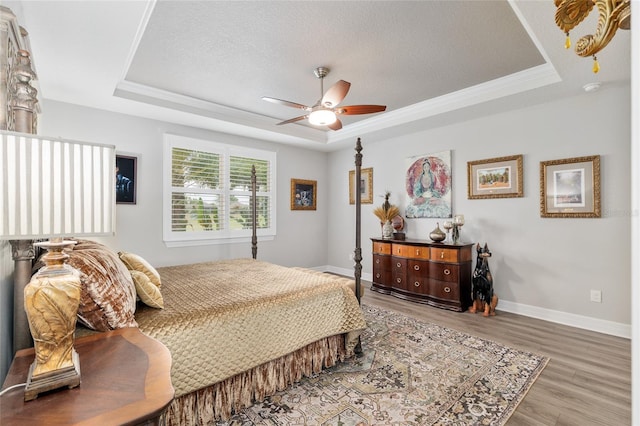 6816 SW 95th Cir, Ocala, FL 34481 - bedroom with ceiling fan, baseboards, wood finished floors, and a tray ceiling