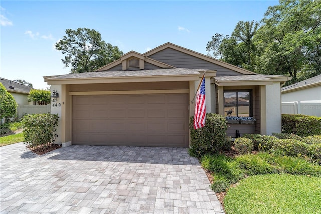 ranch-style house featuring stucco siding, decorative driveway, and a garage