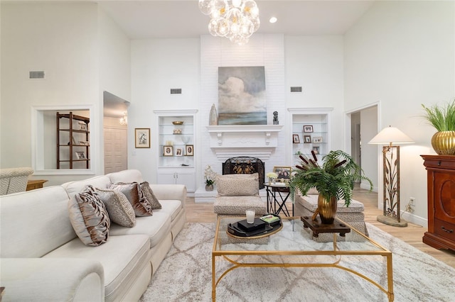 living area with a high ceiling, light wood finished floors, and visible vents