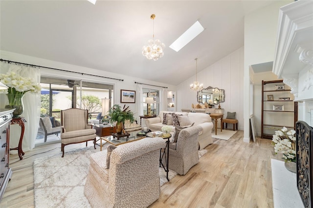 living room featuring a skylight, light wood-style floors, high vaulted ceiling, and a notable chandelier