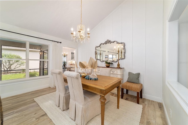 dining room with lofted ceiling, baseboards, light wood-style floors, and a chandelier