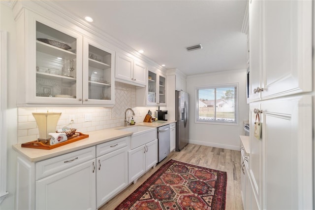 kitchen with visible vents, light wood-style floors, tasteful backsplash, appliances with stainless steel finishes, and white cabinetry