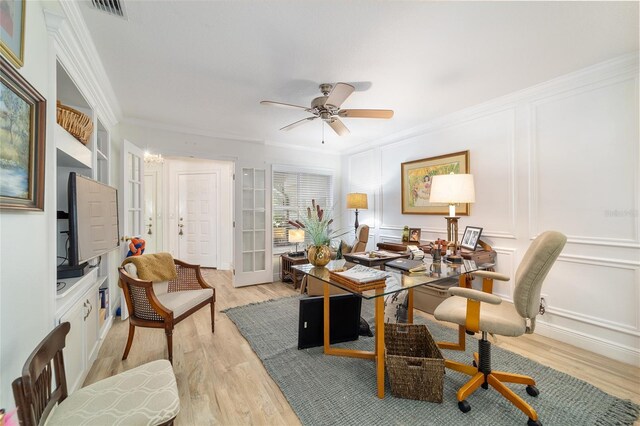 office space featuring crown molding, light wood-style floors, and visible vents