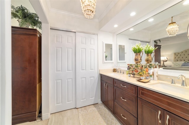 bathroom featuring recessed lighting, crown molding, a sink, and an inviting chandelier