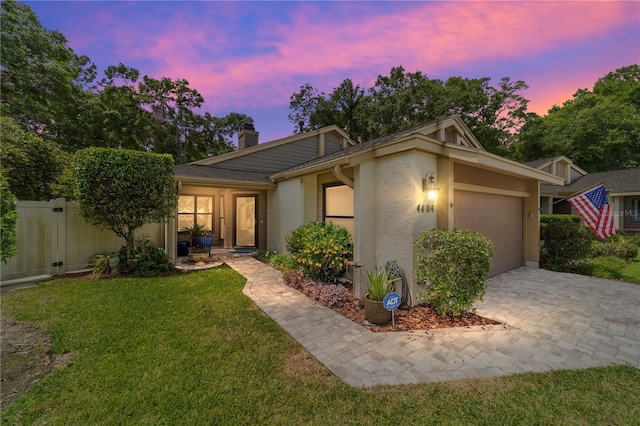single story home with a chimney, fence, a yard, a garage, and stucco siding