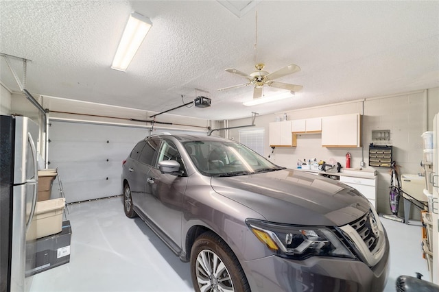 garage featuring ceiling fan, a garage door opener, and freestanding refrigerator