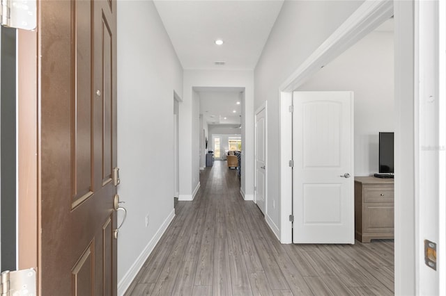 corridor with recessed lighting, baseboards, and light wood-style flooring