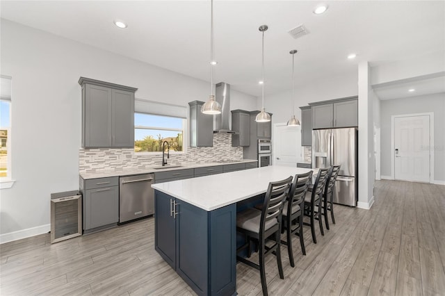 kitchen with a large island, appliances with stainless steel finishes, gray cabinets, and a sink
