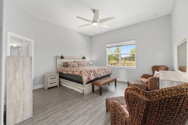 bedroom with baseboards, a ceiling fan, and light wood-style floors