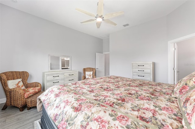 bedroom with light wood finished floors, visible vents, and ceiling fan