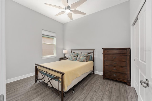 bedroom featuring baseboards, wood finished floors, and ceiling fan