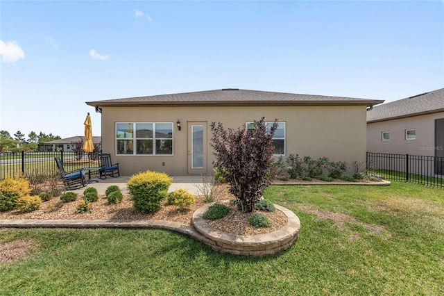 back of property featuring fence, a lawn, a patio area, and stucco siding