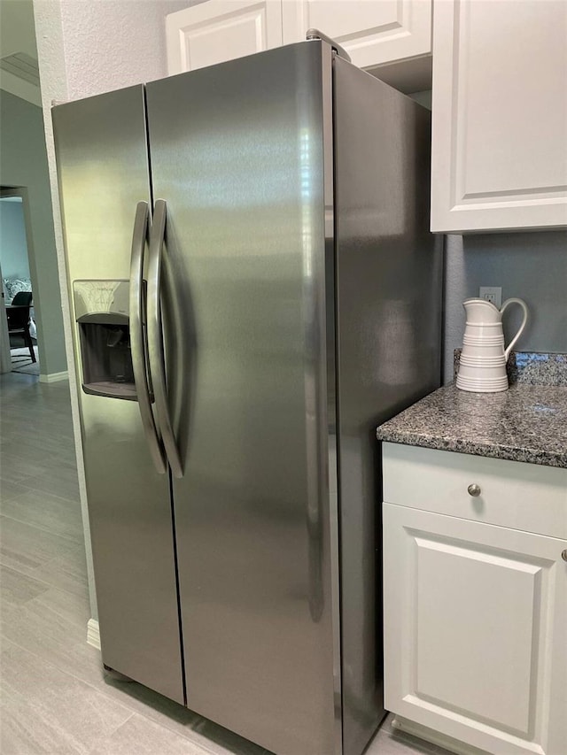 6432 NW 64th Ter, Ocala, FL 34482 - kitchen featuring stainless steel fridge, white cabinets, and dark stone countertops