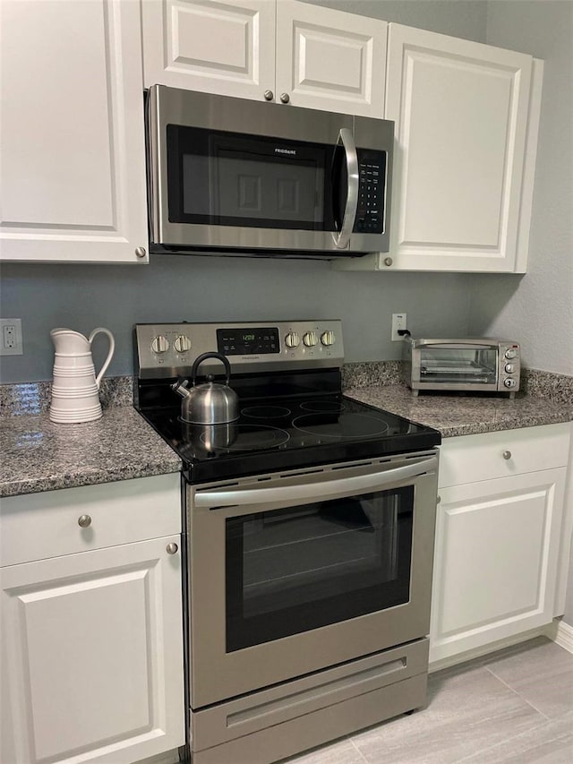 6432 NW 64th Ter, Ocala, FL 34482 - kitchen featuring stainless steel appliances, white cabinets, and dark stone countertops