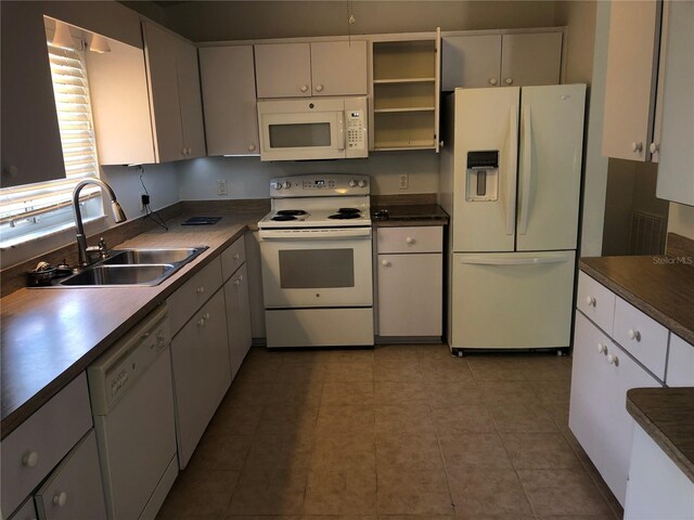 9896 SW 61st Ct, Ocala, FL 34476 - kitchen featuring dark countertops, open shelves, a sink, white appliances, and white cabinetry