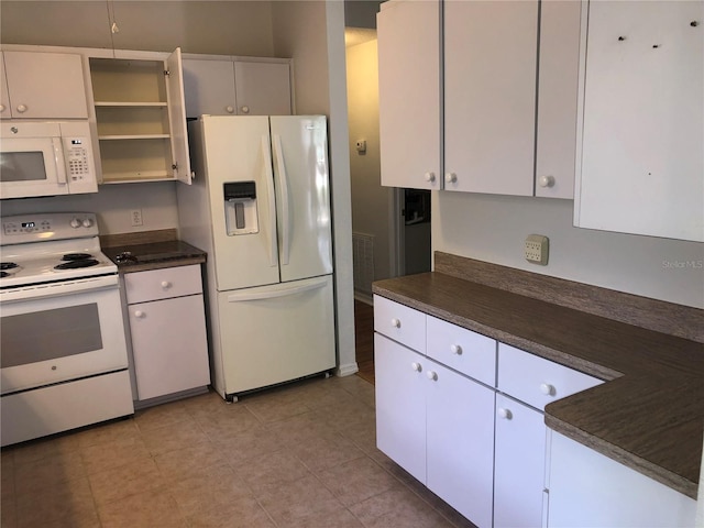 9896 SW 61st Ct, Ocala, FL 34476 - kitchen featuring dark countertops, open shelves, light tile patterned floors, white cabinets, and white appliances