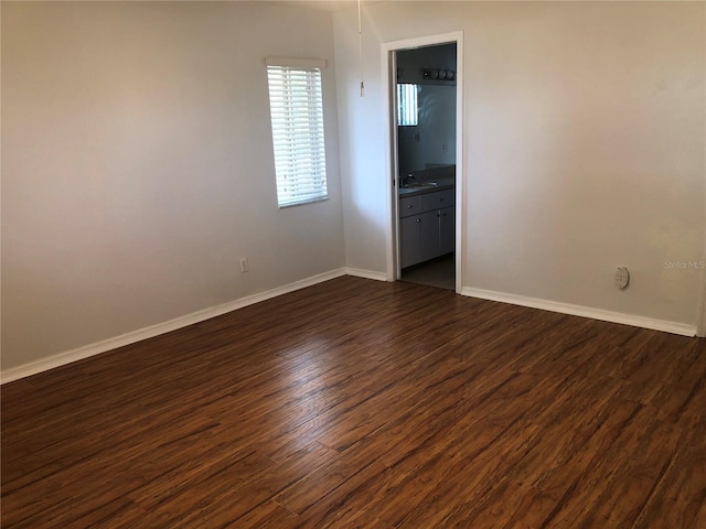 9896 SW 61st Ct, Ocala, FL 34476 - unfurnished room with baseboards, a sink, and dark wood-style flooring