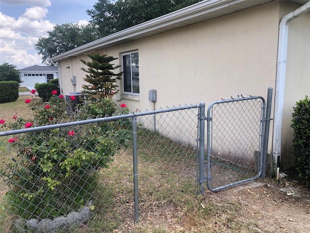 9896 SW 61st Ct, Ocala, FL 34476 - view of home's exterior with stucco siding, a gate, and fence