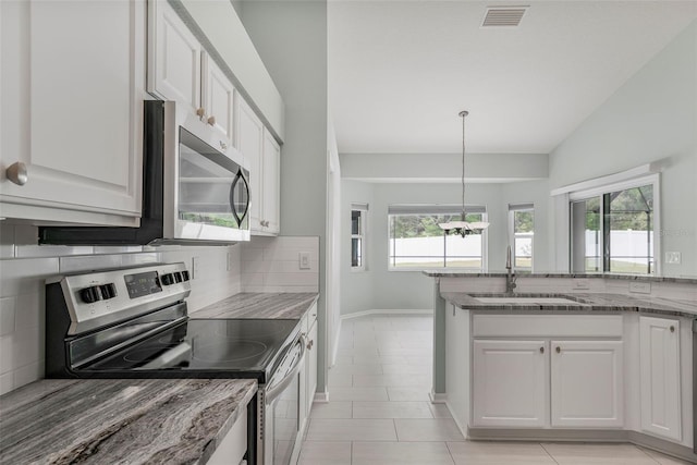kitchen with light stone counters, a sink, decorative backsplash, appliances with stainless steel finishes, and visible vents
