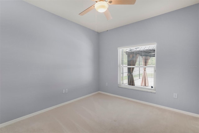 empty room with carpet flooring, baseboards, and a ceiling fan