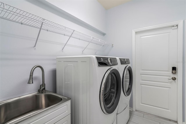 washroom with separate washer and dryer, a sink, and laundry area