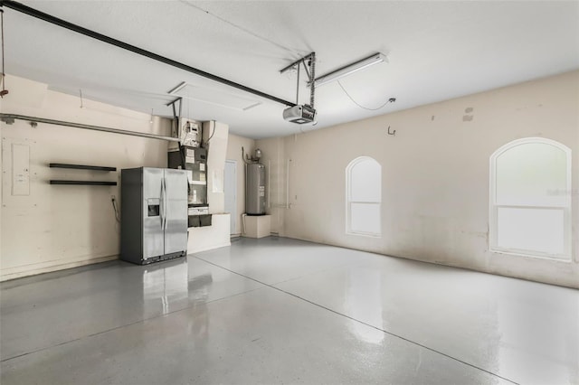 garage featuring heating unit, stainless steel fridge with ice dispenser, a garage door opener, and electric water heater