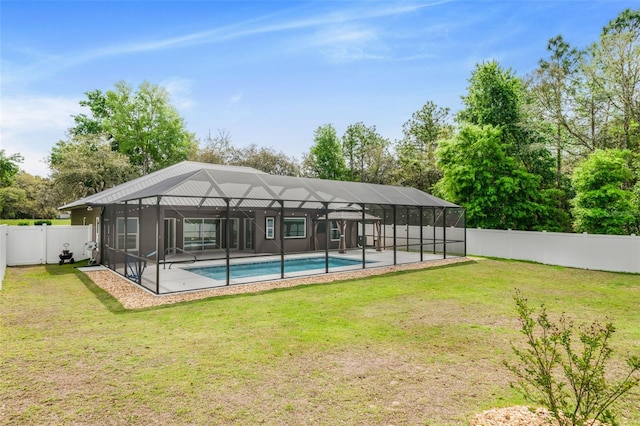 rear view of house with a fenced backyard, a yard, a fenced in pool, and glass enclosure