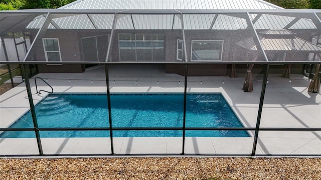 pool with glass enclosure and a patio