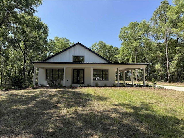 18890 SW 60th St, Dunnellon, FL 34432 - view of front of home with concrete driveway, a front yard, french doors, and an attached carport