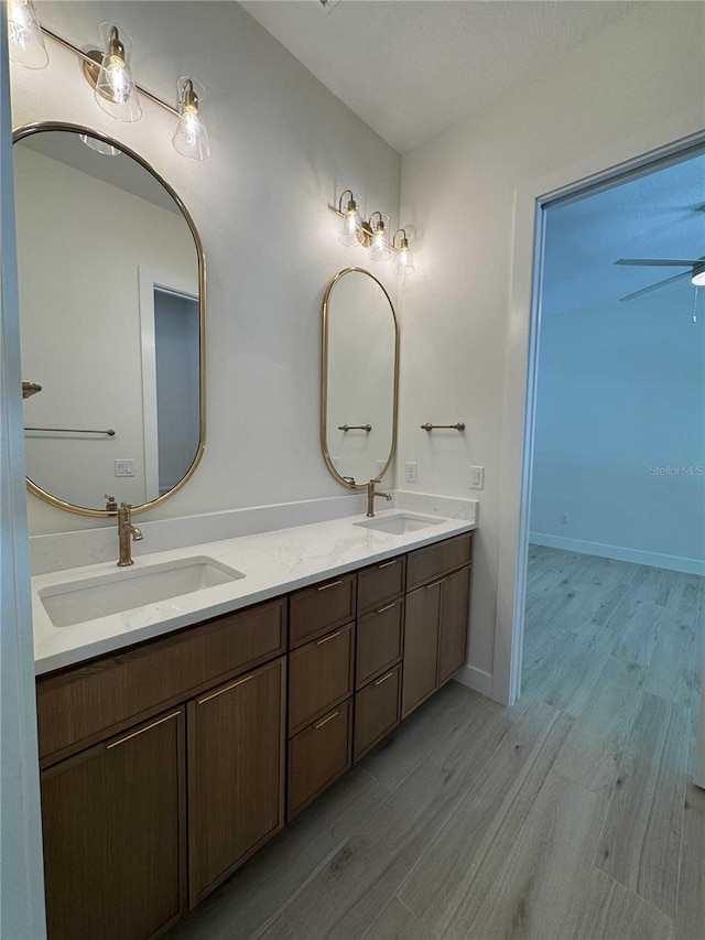 18890 SW 60th St, Dunnellon, FL 34432 - full bath with double vanity, wood finished floors, a ceiling fan, and a sink