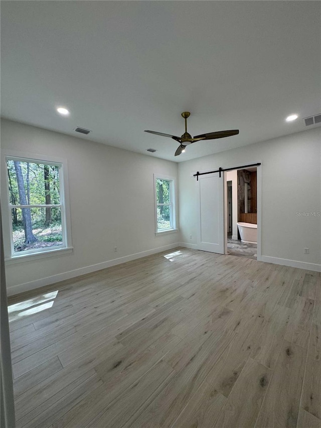 18890 SW 60th St, Dunnellon, FL 34432 - empty room with visible vents, a barn door, and baseboards