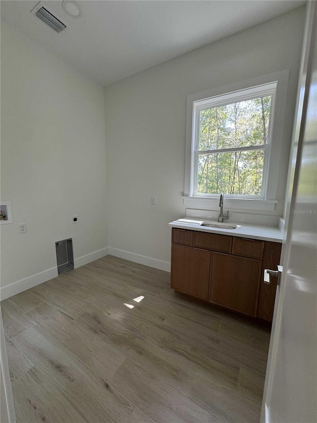 18890 SW 60th St, Dunnellon, FL 34432 - washroom featuring light wood-style flooring, a sink, visible vents, hookup for a washing machine, and cabinet space