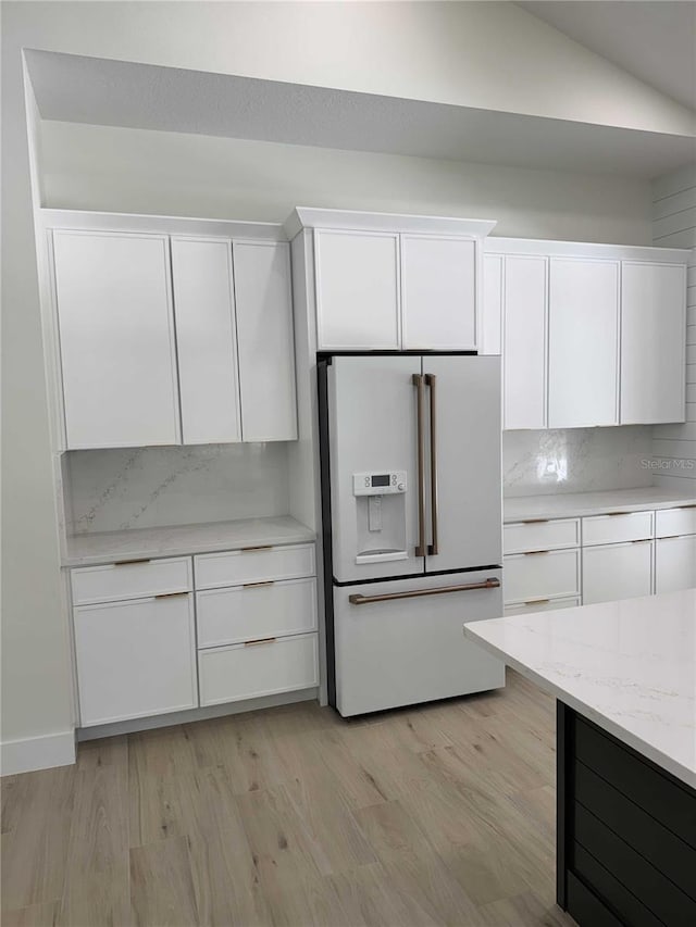 18890 SW 60th St, Dunnellon, FL 34432 - kitchen with white fridge with ice dispenser, white cabinets, light wood-type flooring, and decorative backsplash