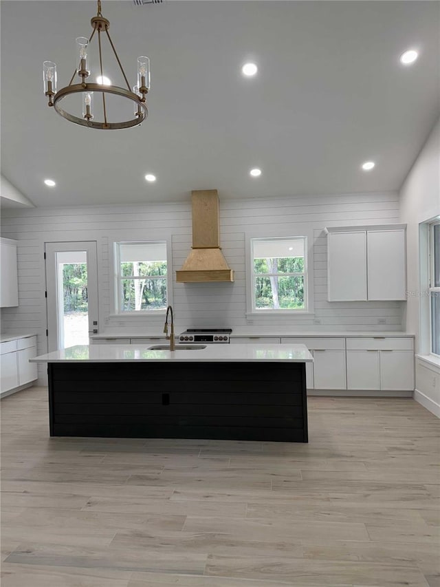 18890 SW 60th St, Dunnellon, FL 34432 - kitchen featuring white cabinetry, a sink, light countertops, an inviting chandelier, and custom exhaust hood