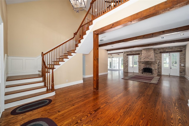 950 SW 43rd Pl, Ocala, FL 34471 - unfurnished living room with a fireplace, wood finished floors, stairway, beamed ceiling, and an inviting chandelier