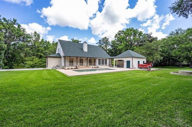 950 SW 43rd Pl, Ocala, FL 34471 - rear view of house with a chimney, a lawn, an outdoor pool, a patio area, and an outdoor structure