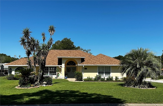 view of front of home featuring stucco siding and a front lawn