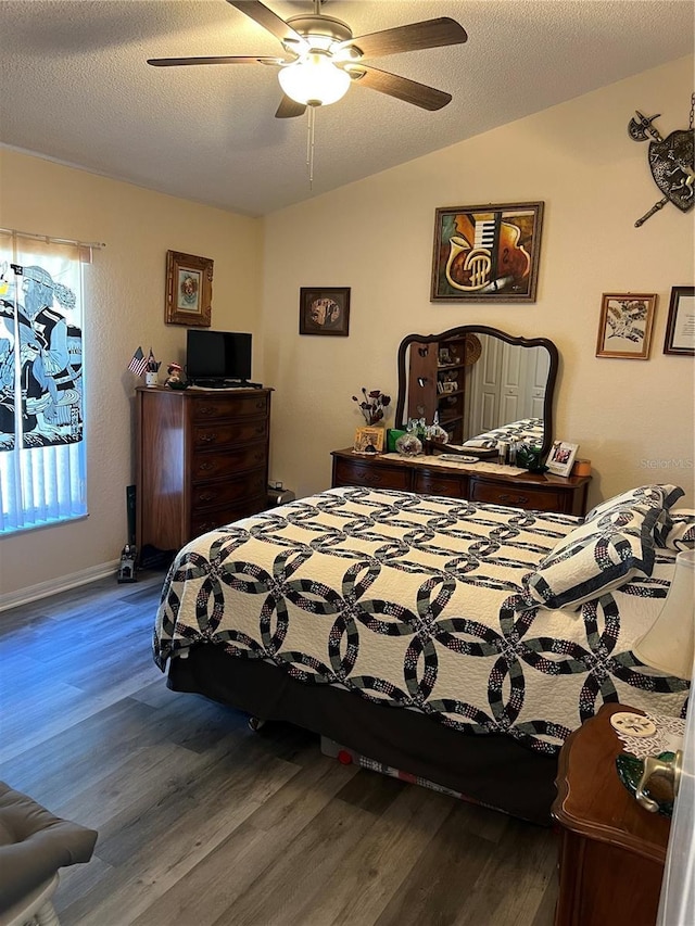 bedroom featuring lofted ceiling, baseboards, a ceiling fan, and wood finished floors