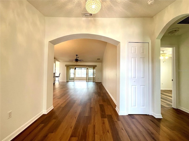 15782 SW 16th Avenue Rd, Ocala, FL 34473 - hallway with arched walkways, a textured ceiling, dark wood finished floors, baseboards, and visible vents