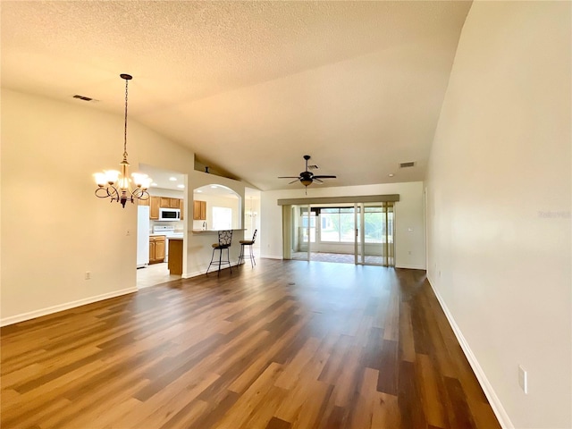 15782 SW 16th Avenue Rd, Ocala, FL 34473 - unfurnished living room with vaulted ceiling, dark wood-type flooring, visible vents, and ceiling fan with notable chandelier